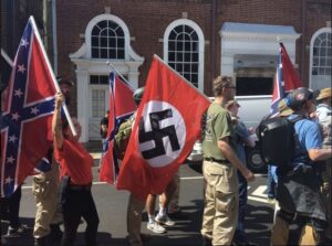 street scene of people carrying flags with extremist symbolism